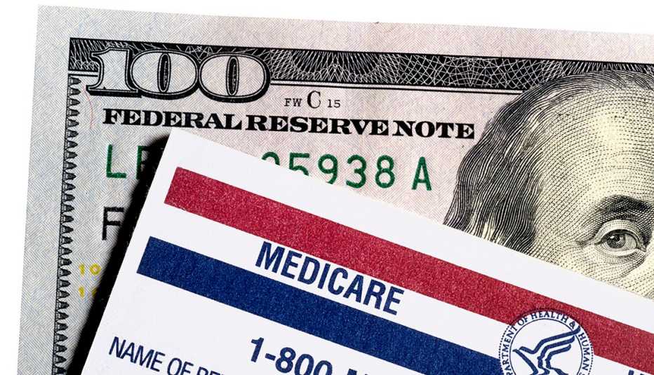 Una tarjeta de Medicare puesta encima de un billete de cien dólares