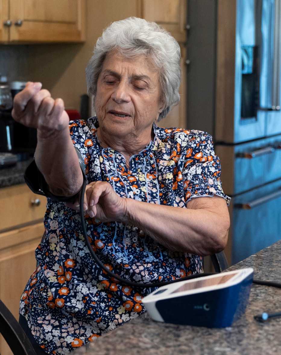 Pat Cutillo, de 85 años, demuestra el proceso de control de su presión arterial