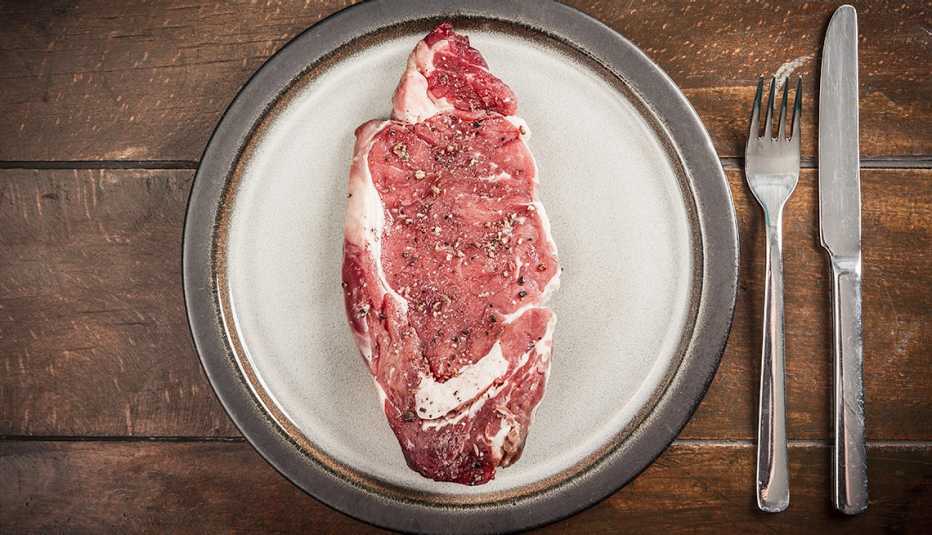 Carne cruda en un plato - Carnes rojas y el cáncer