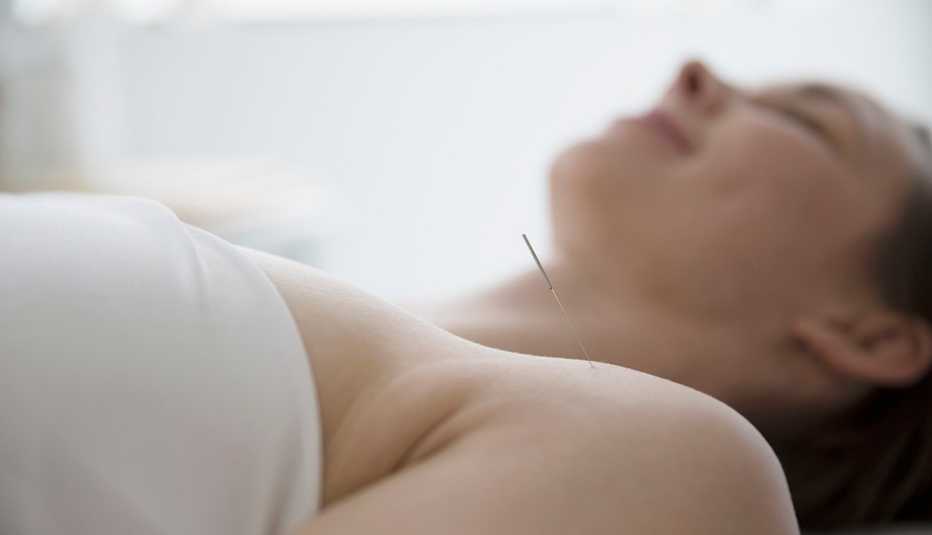 Mujer siendo tratada con acupuntura