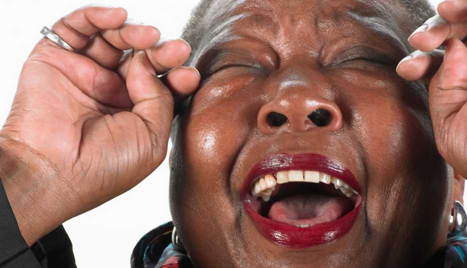 Mujer afro-america riéndose a carcajadas.