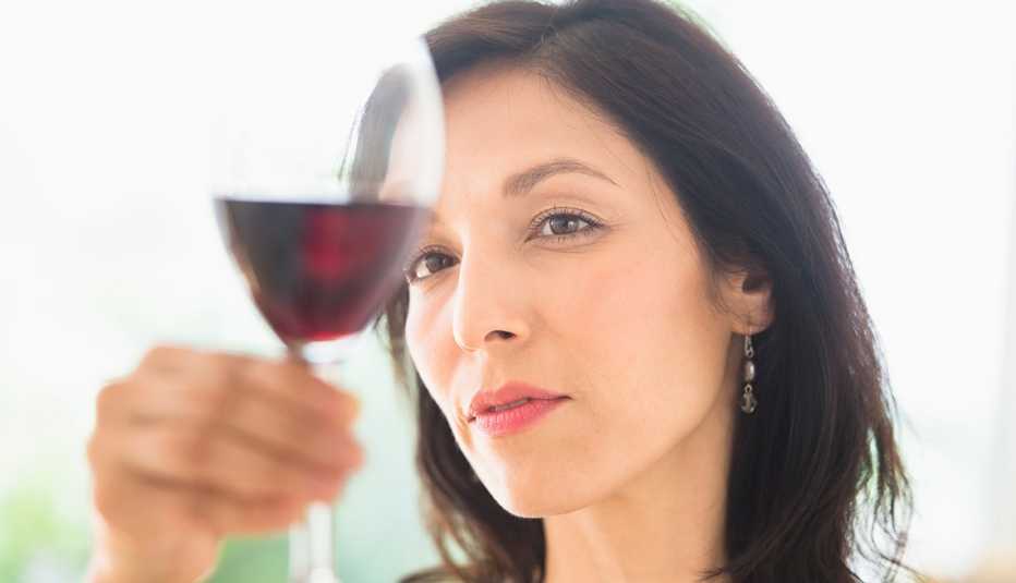 Mujer mirando su copa de vino