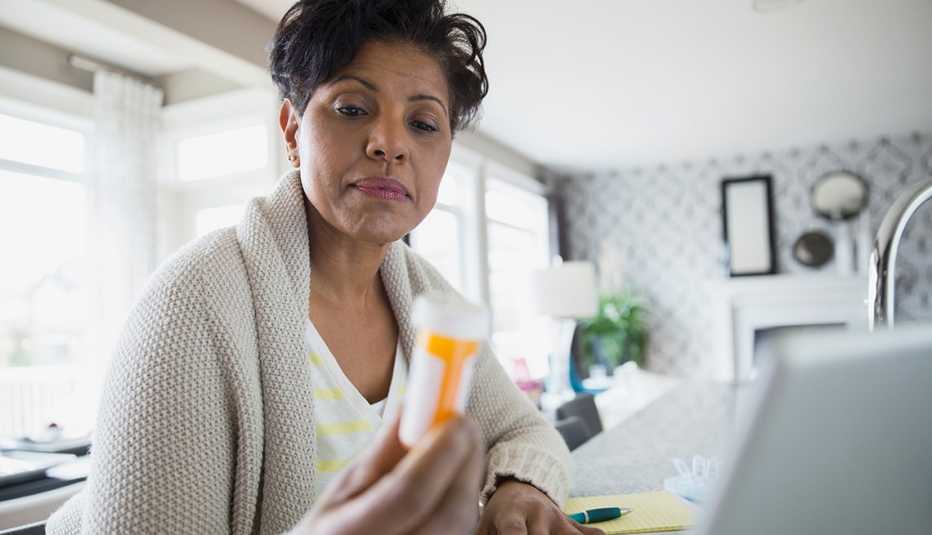 Mujer examinando un frasco de medicamentos