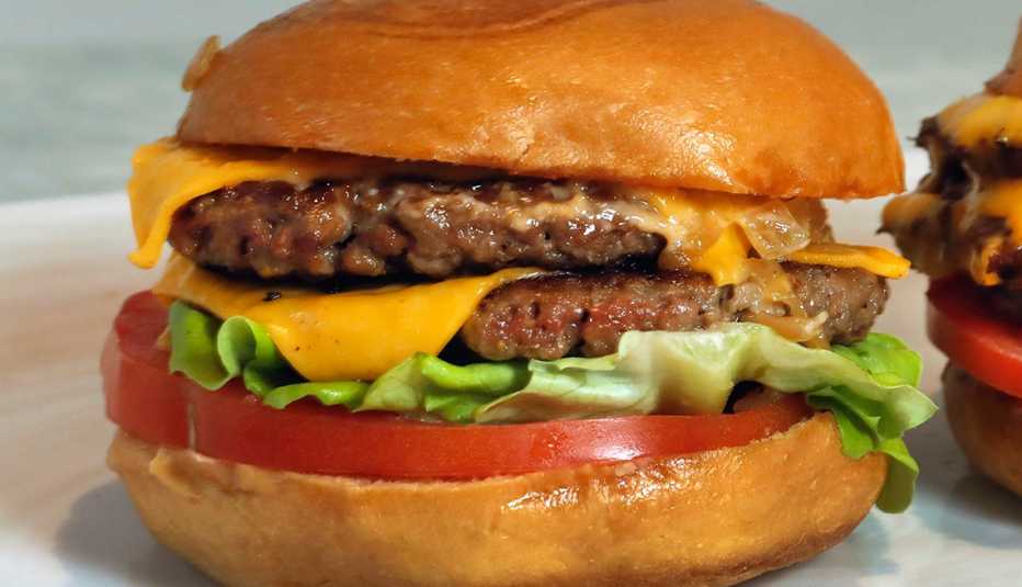 Una hamburguesa con doble carne, queso, lechuga y tomate