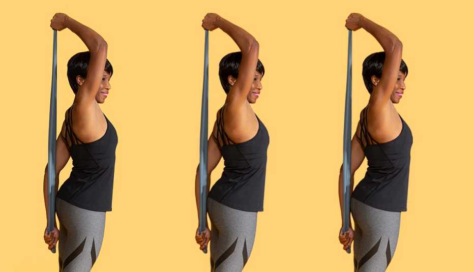 Una mujer usa una banda elástica para hacer ejercicios de estiramiento