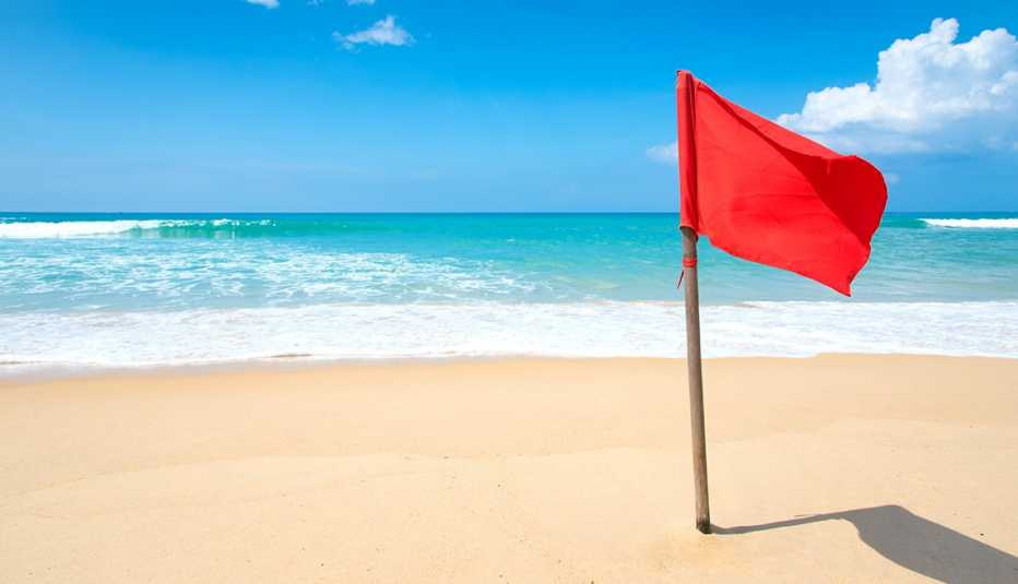 Bandera roja en una playa bonita con un cielo azul