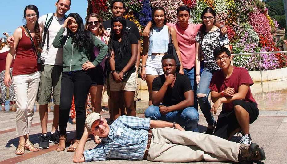 Gary Nees recostado en el suelo con un grupo de estudiantes en España en el 2015 - Ganar dinero en la jubilación