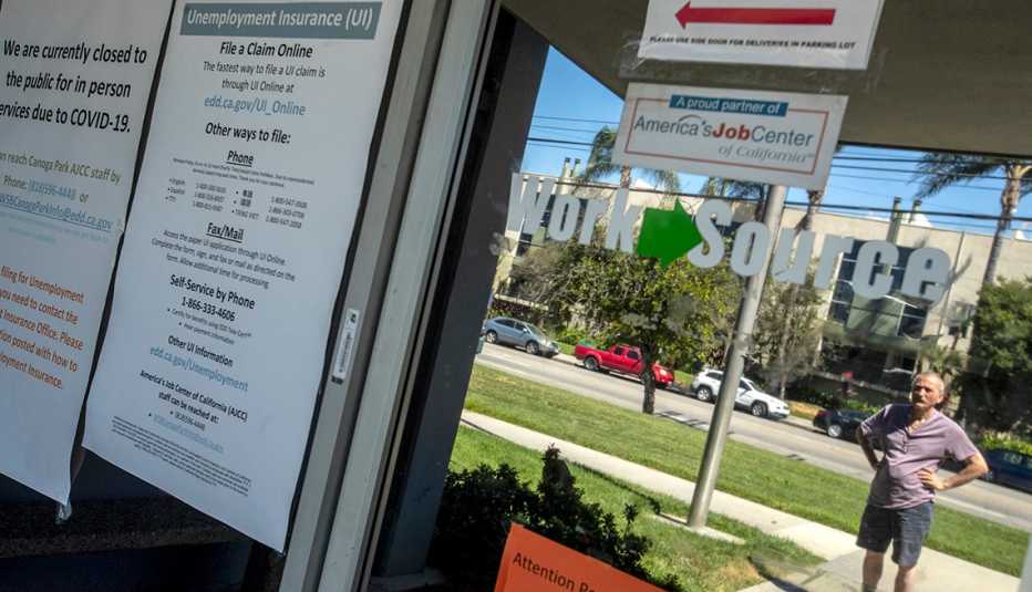 Un hombre lee anuncios en la ventana del Departamento del Desarrollo del Empleo del estado de California, el cual se encuentra cerrado.