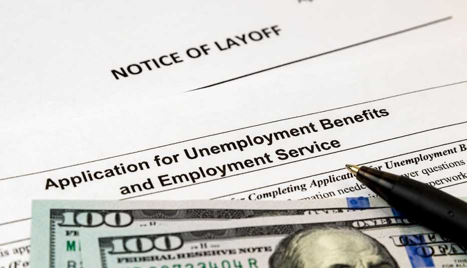 Notificación de despido, formulario de beneficios de desempleo y dos billetes de 100 dólares.