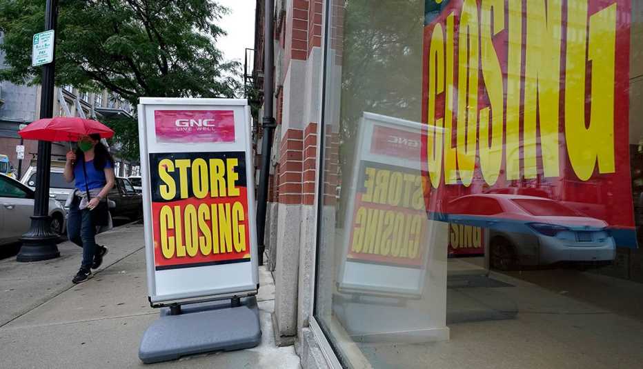 Vitrina de una tienda de GNC y una pancarta afuera que en inglés tienda en proceso de cierre.