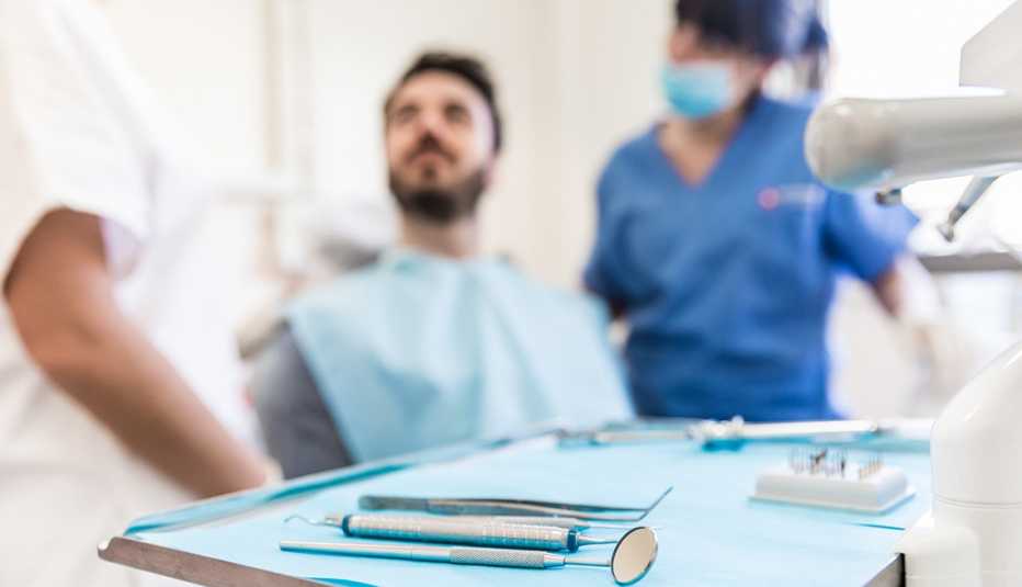 Dentista, una asistente y un paciente en un consultorio dental