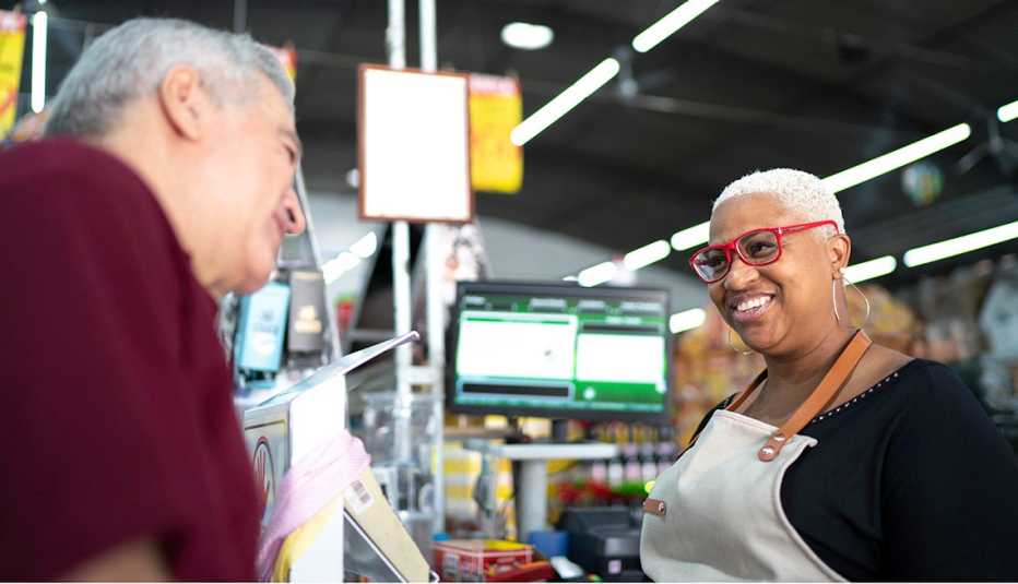 Cajera sonríe a un cliente en un supermercado