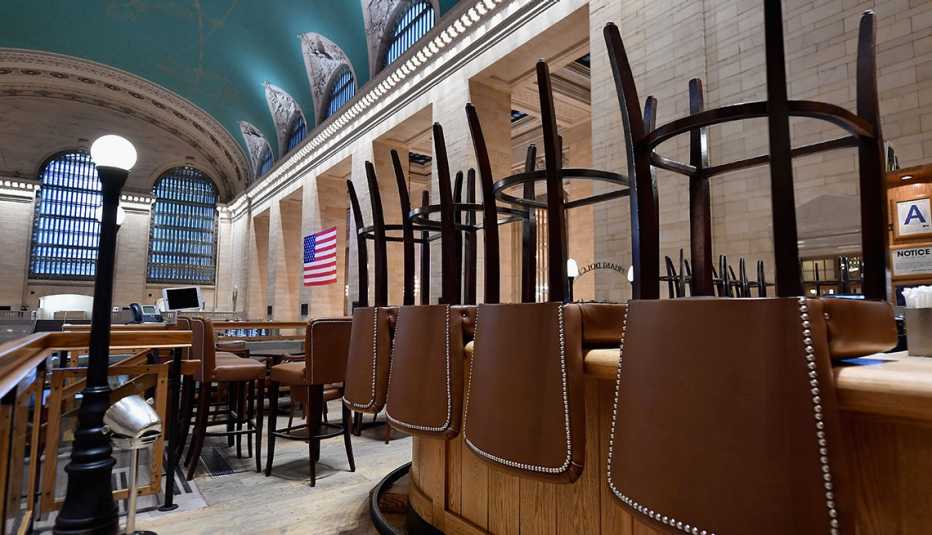 Restaurante vacío con las sillas volteadas sobre las mesas en Grand Central, Nueva York,