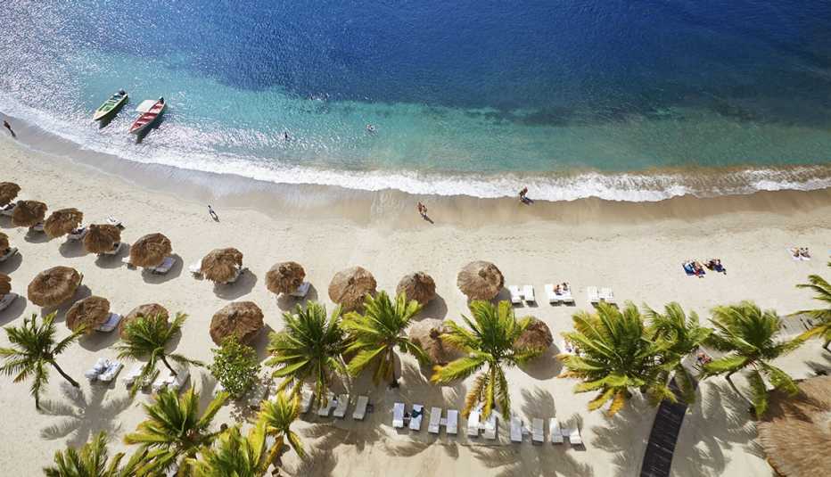 Vista aérea de cabañas, palmeras y playa en Soufriere, Santa Lucía