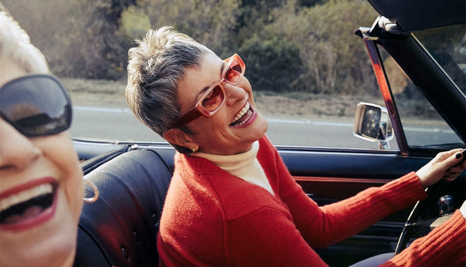 Dos mujeres sonríen durante un viaje por carretera