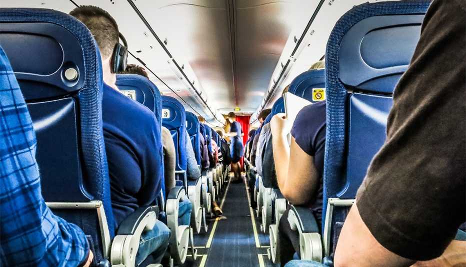 Pasajeros de un avión sentados en sus sillas