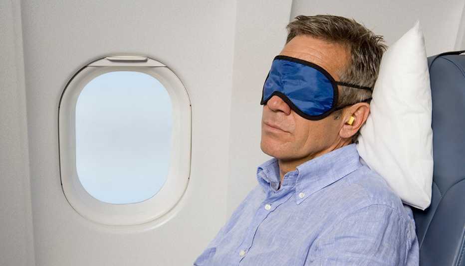 Un hombre duerme en un avión.