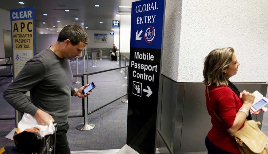 Un hombre y una mujer entran en un control de aduanas en un aeropuerto