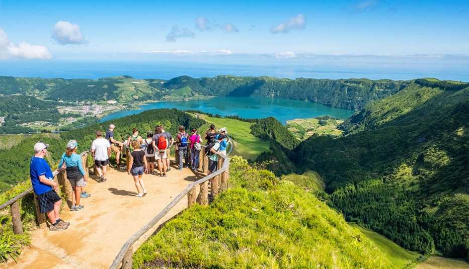 Turistas en un mirador en Sete Cidades, dos lagos y un pueblo en el cráter inactivo de un volcán en la isla de Sao Miguel, Islas Azores