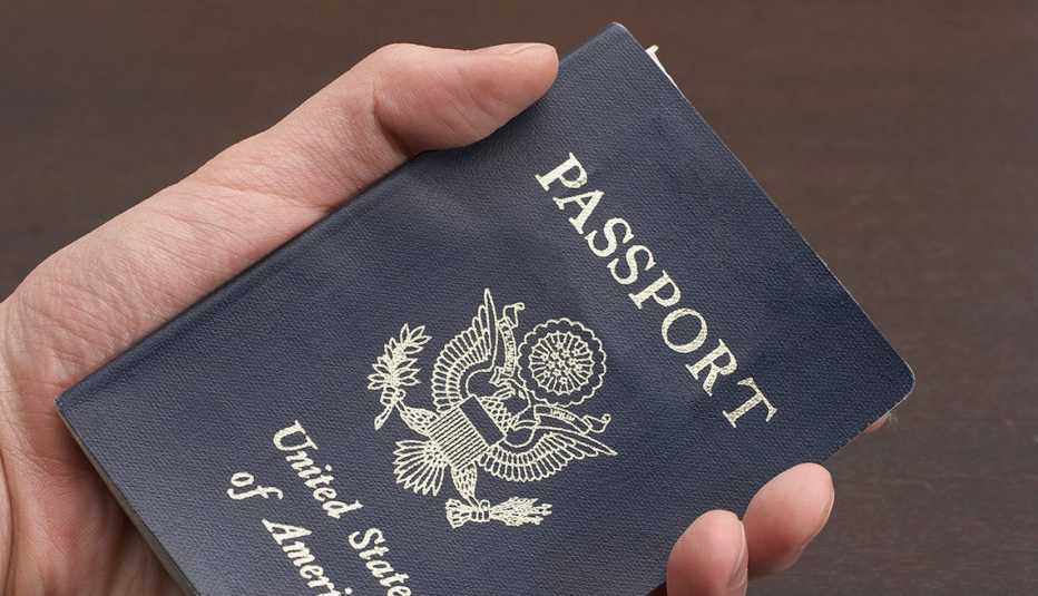 Persona sostiene un pasaporte en la mano