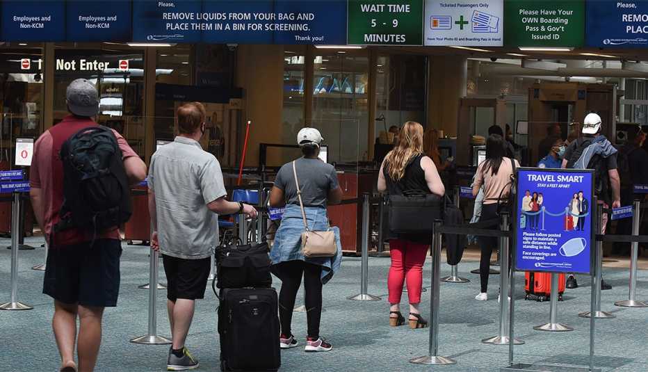Un letrero recuerda a los pasajeros que se mantengan a 6 pies de distancia en el Aeropuerto Internacional de Orlando