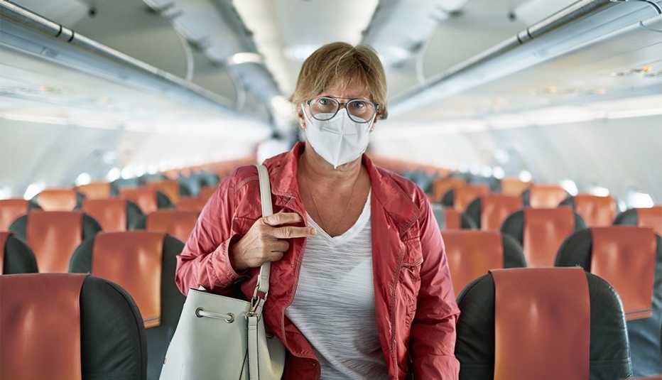 Mujer con máscara viaja en un avión comercial