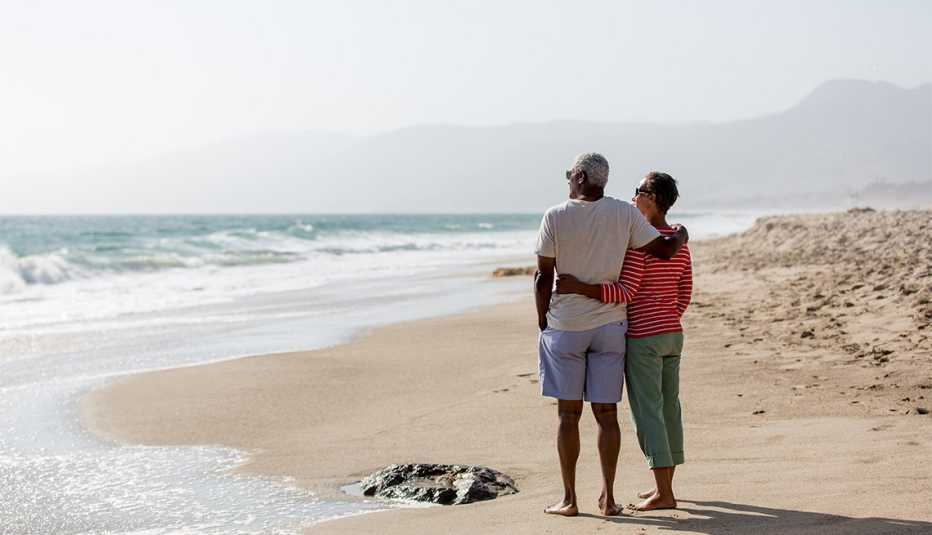 Un hombre y una mujer parados en la playa