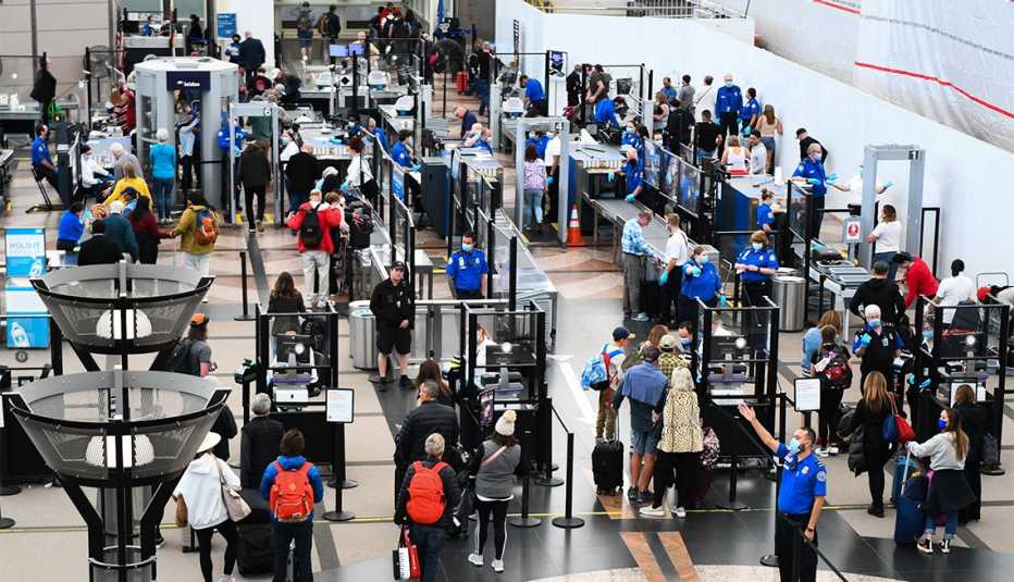 Pasajeros de líneas aéreas hacen la fila de seguridad en el aeropuerto