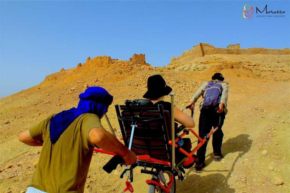 Turistas suben una colina árida en Ait Ben Haddou en Marruecos
