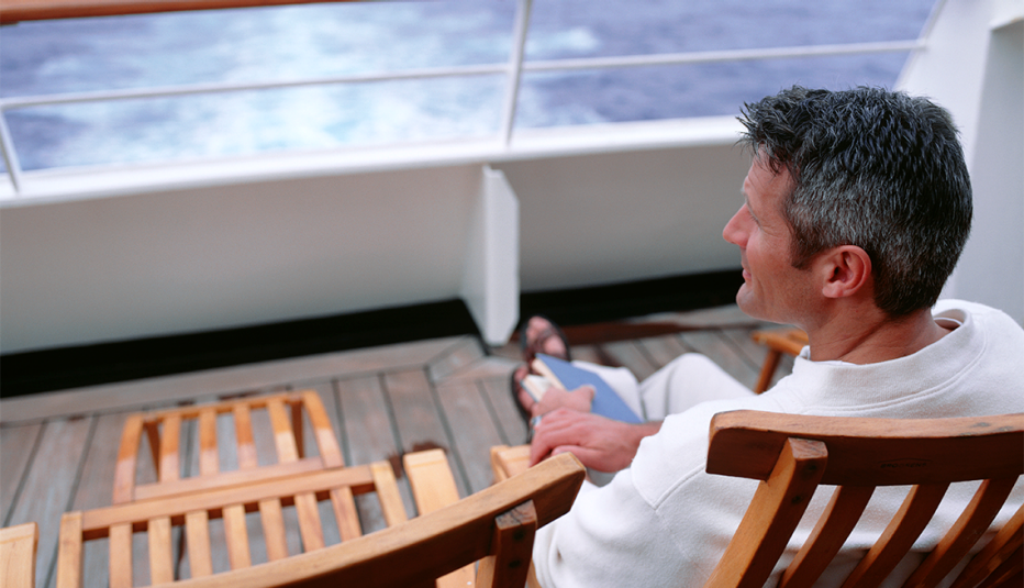 un hombre en la cubierta de un crucero con un libro 