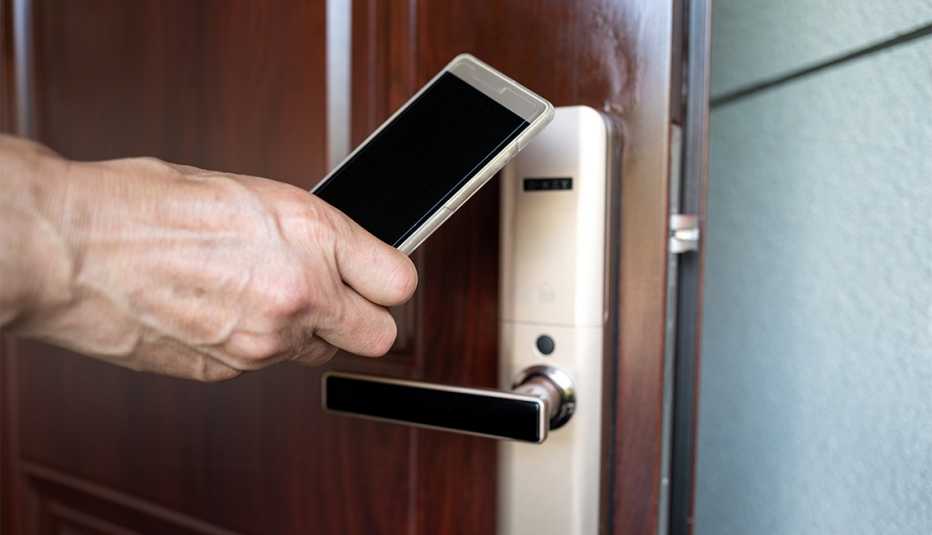 Persona usa teléfono móvil para abrir una puerta de la habitación del hotel