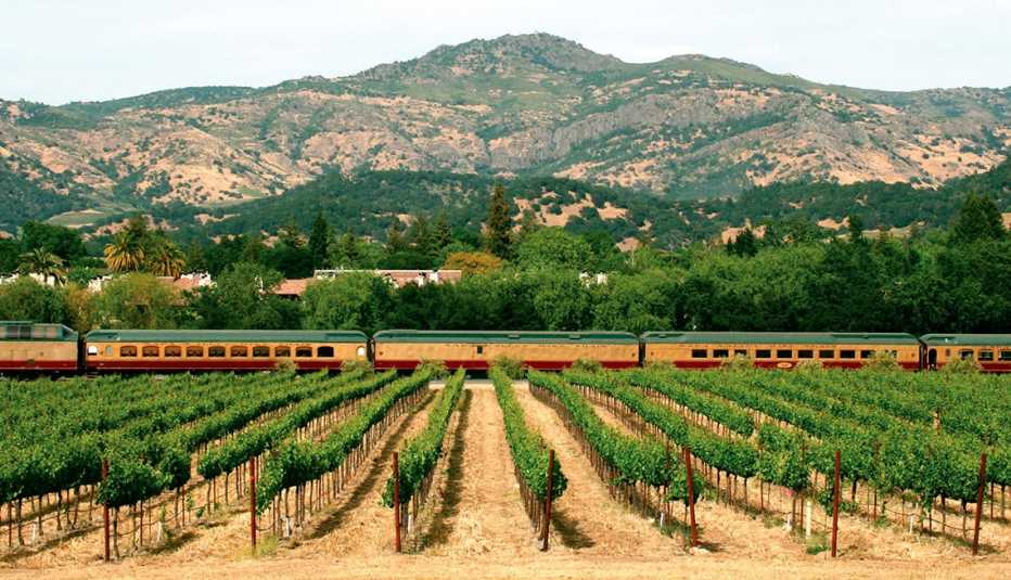 El Napa Valley Wine Train pasando por viñedos y montañas en el valle de Napa, California