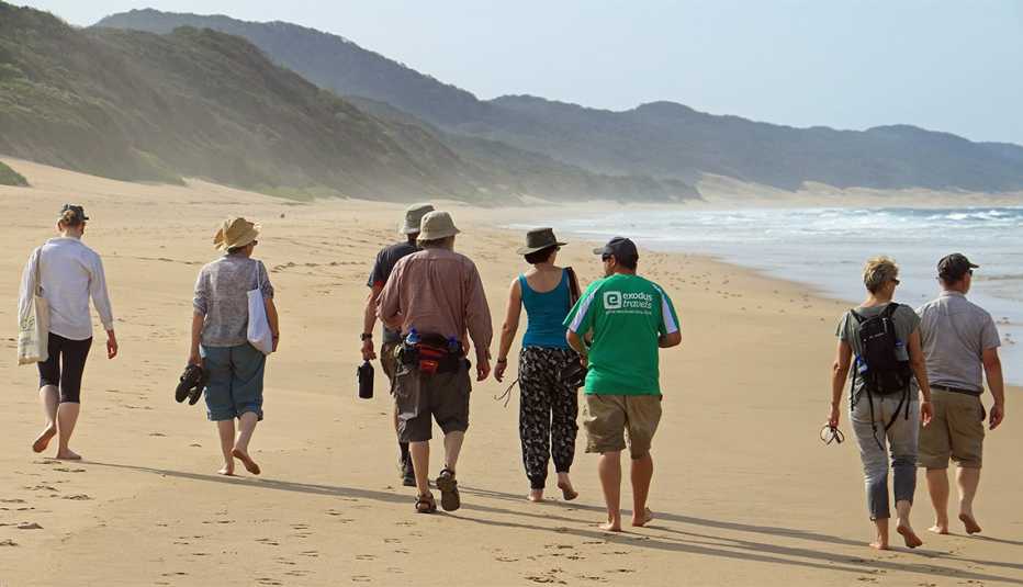 Grupo de personas caminan en la playa