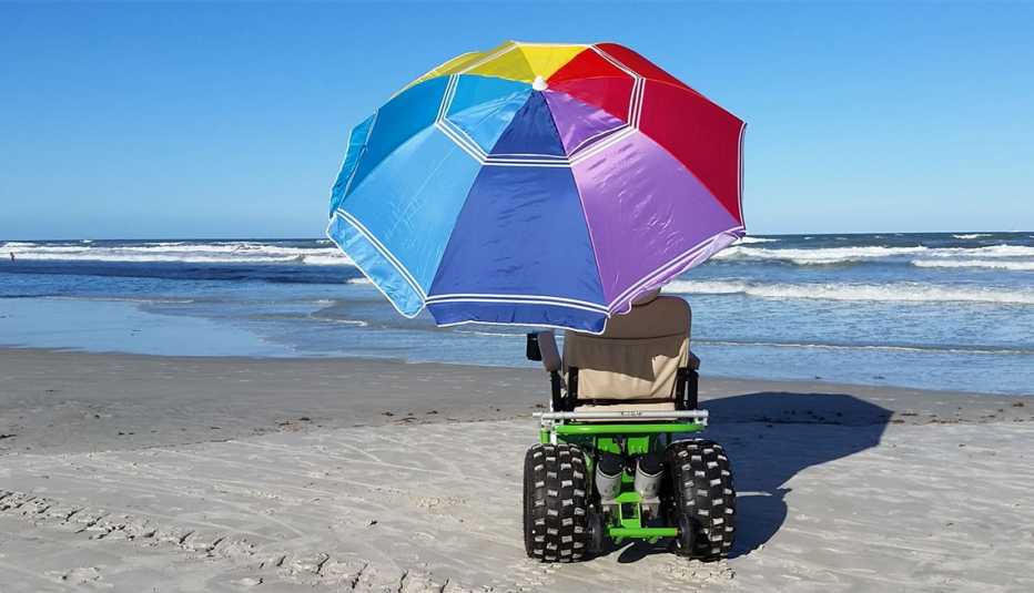 una silla de ruedas de playa disponible para alquilar, con una sombrilla incluida, en Daytona Beach, Florida