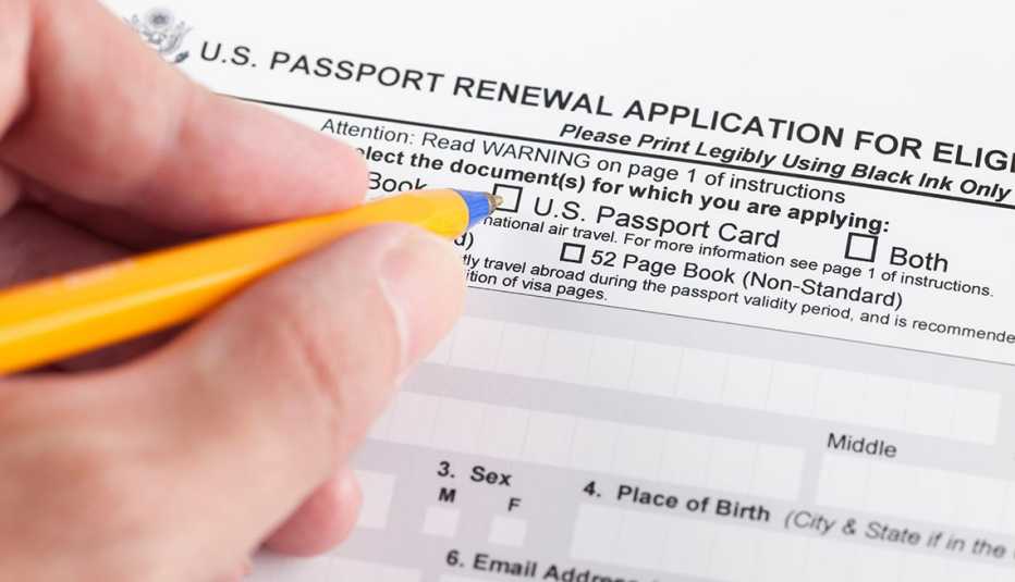 Mano de una persona llenando un formulario para solicitar un pasaporte