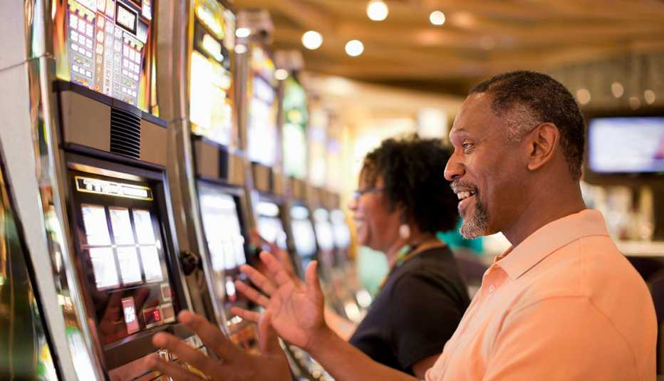 una pareja sonríe mientras juega con máquinas en un casino
