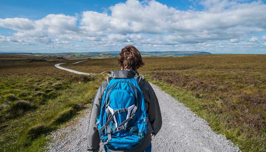 Una mujer con mochila azul recorre el sendero de montaña Cuilcagh en Irlanda.