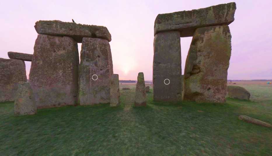 Captura de pantalla del recorrido virtual de Stonehenge que muestra el amanecer en la distancia y varias de las piedras