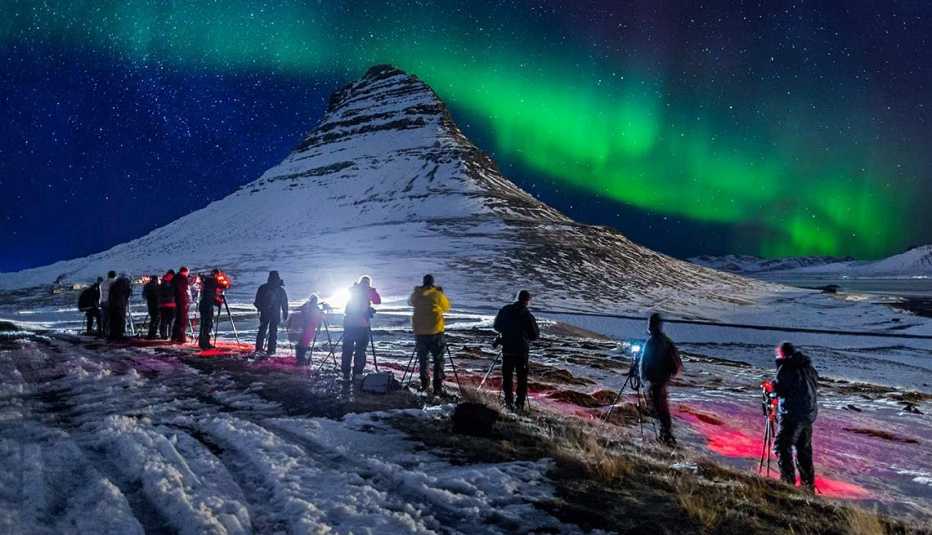 Grupo de fotógrafos capturando una aurora boreal