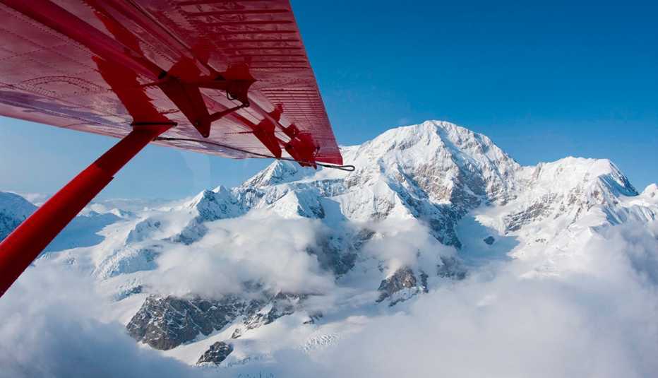 Ala de un avión cerca a una montaña nevada
