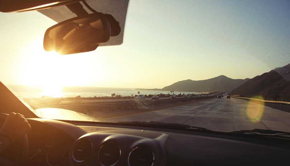 Mujer conduce su auto en una carretera de la costa pacífica de Estados Unidos