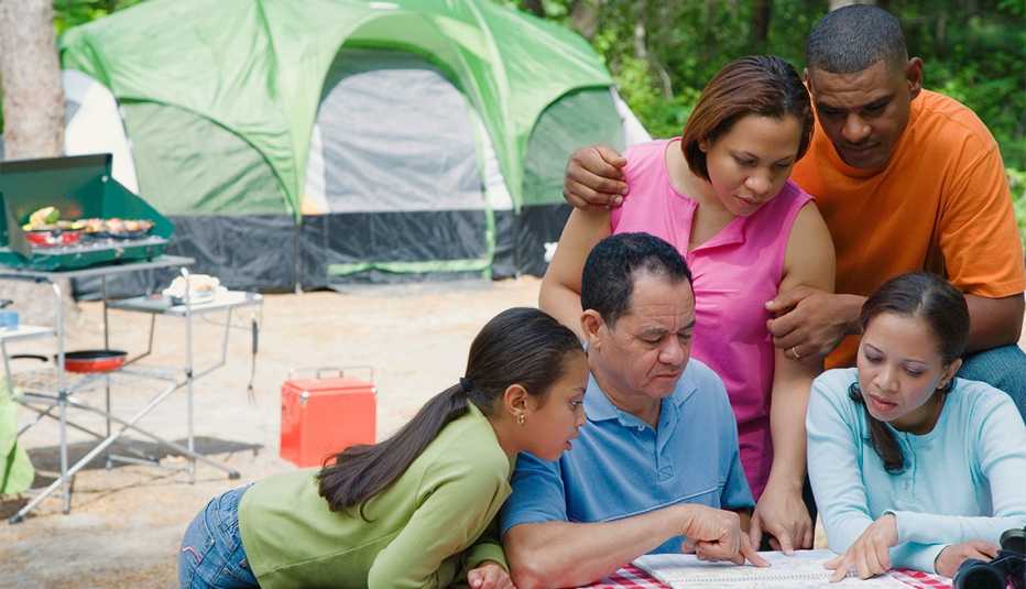 Familia observa un mapa mientras acampa