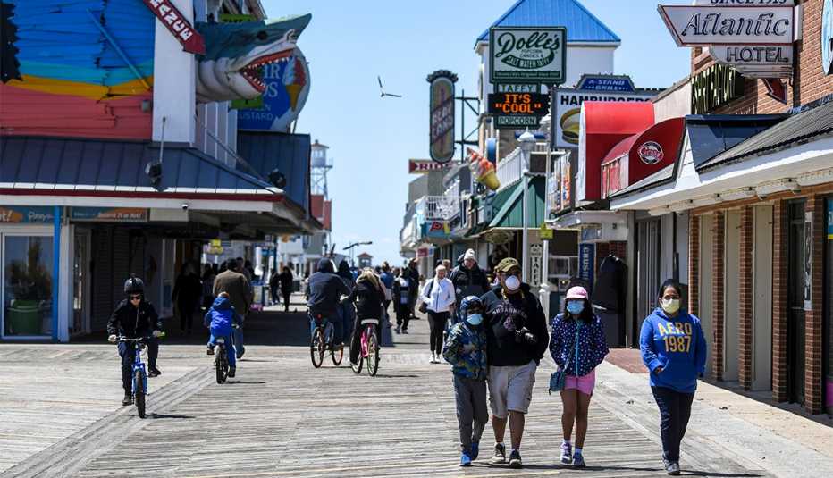 Gente camina por el paseo marítimo de Ocean City, MD