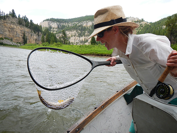 Mujer pescando en un pequeño bote en Montana