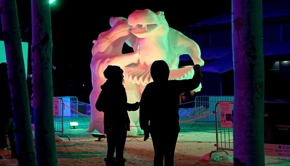Dos personas obervan una escultura de hielo.