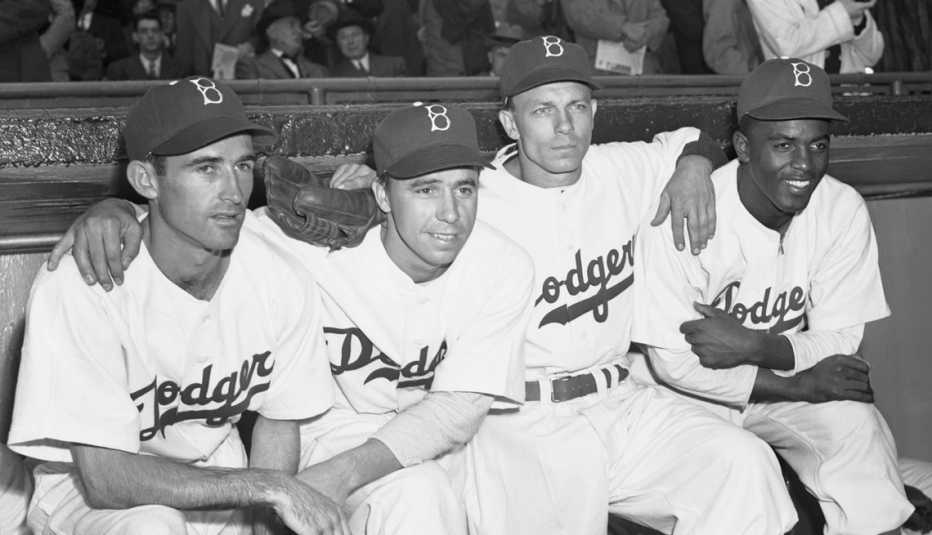 Jackie Robinson sentado en el banco con sus compañeros de equipo de los Dodgers de Brooklyn