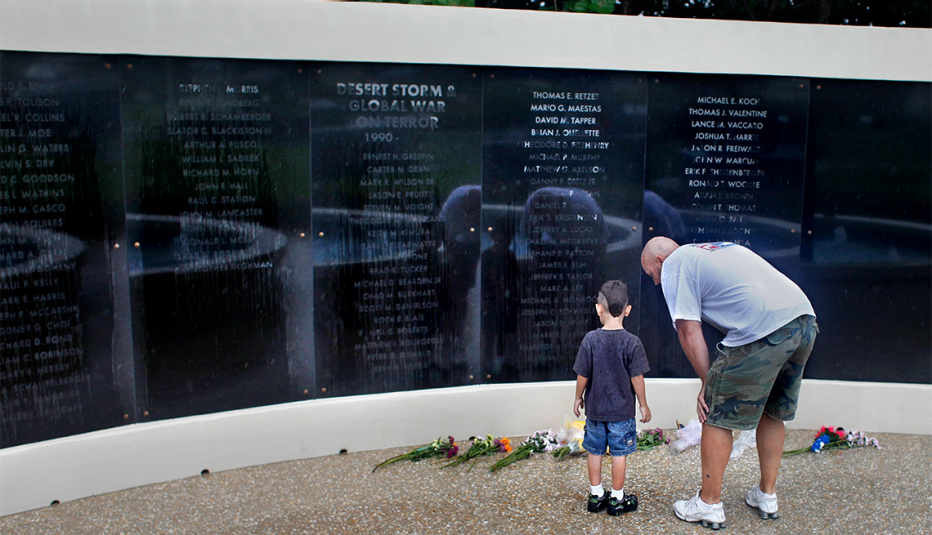 Un padre con su hijo pequeño visitan un monumento en homenaje a los Navy Seals de la Marina