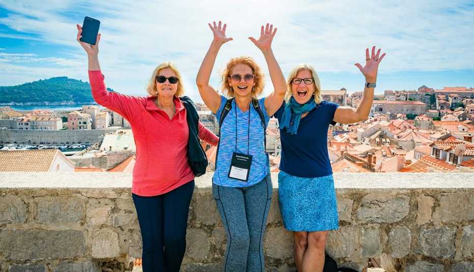 image of three mature women smiling with their hands in their in Dubrovnik