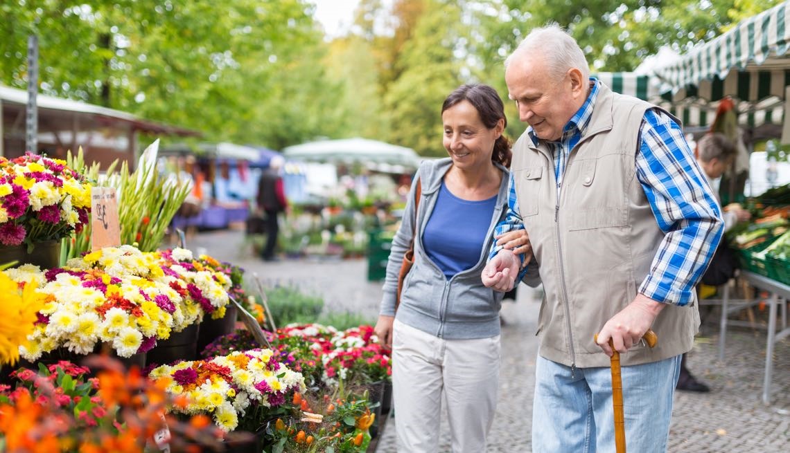 Man and woman walking by flowers at outdoor market
