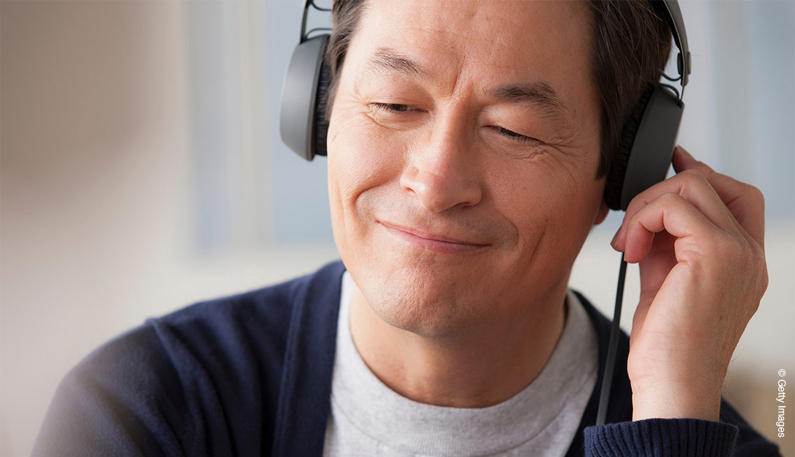 Un asiático escuchando música con sus auriculares